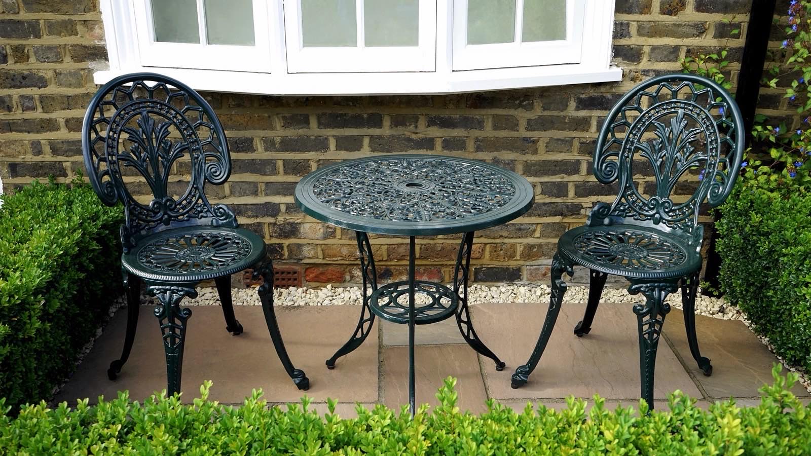 A paved patio with cast-iron garden furniture